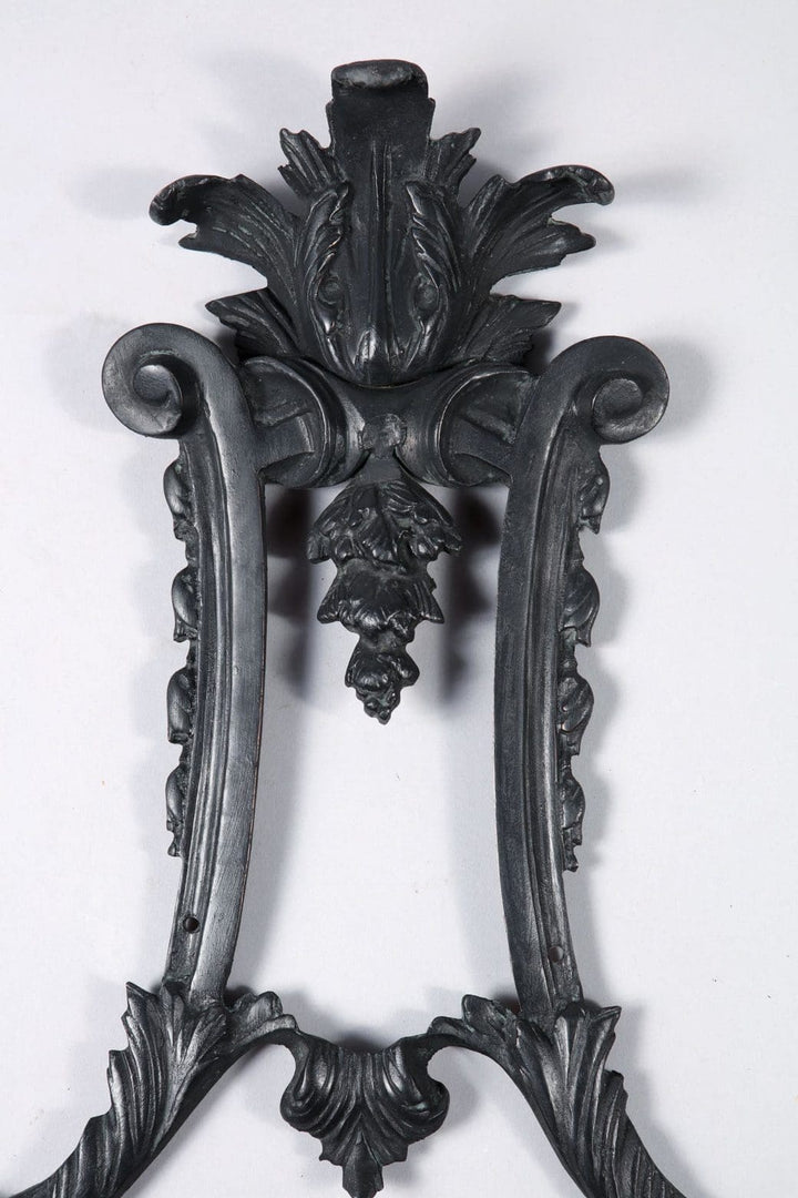 Close-up of ornate dark bronze Louis XIV style wall applique by Collection TH10 with detailed leaf and scroll designs