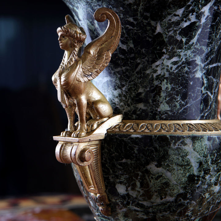 Close-up of gilt bronze sphinx detail on green marble urn by Collection CK20, showcasing exquisite classical Italian craftsmanship.