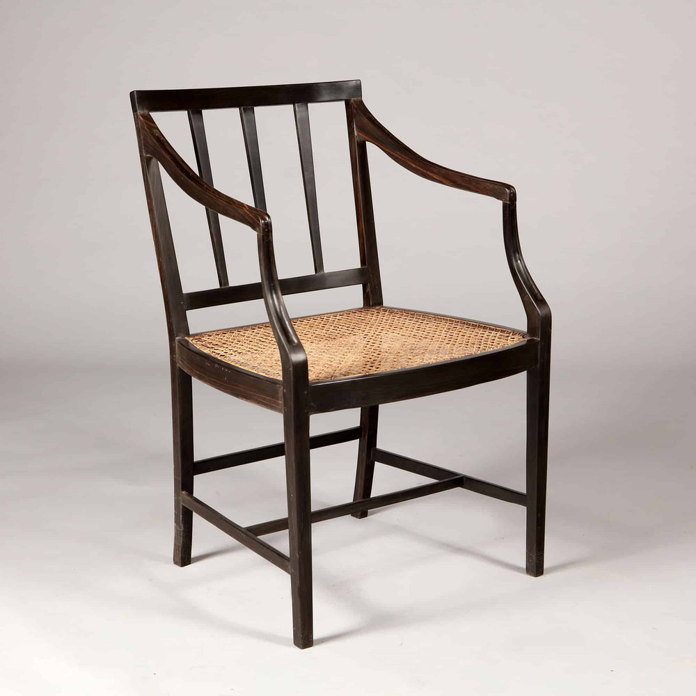 Solid ebony Anglo Indian dining chair with caned seat and spindle back by Collection EE30, circa 2000.