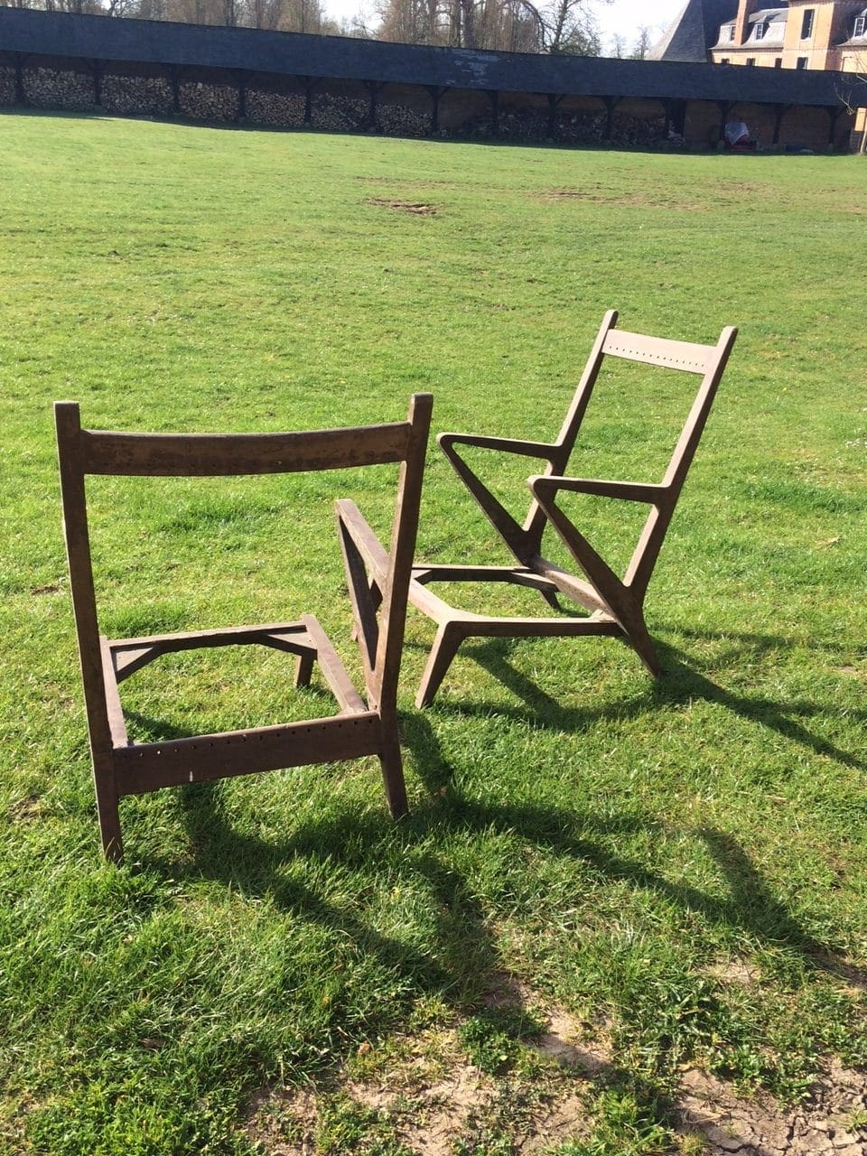Pair of vintage Chandigarh chairs with unique angular teak frames displayed outdoors by Collection EE30
