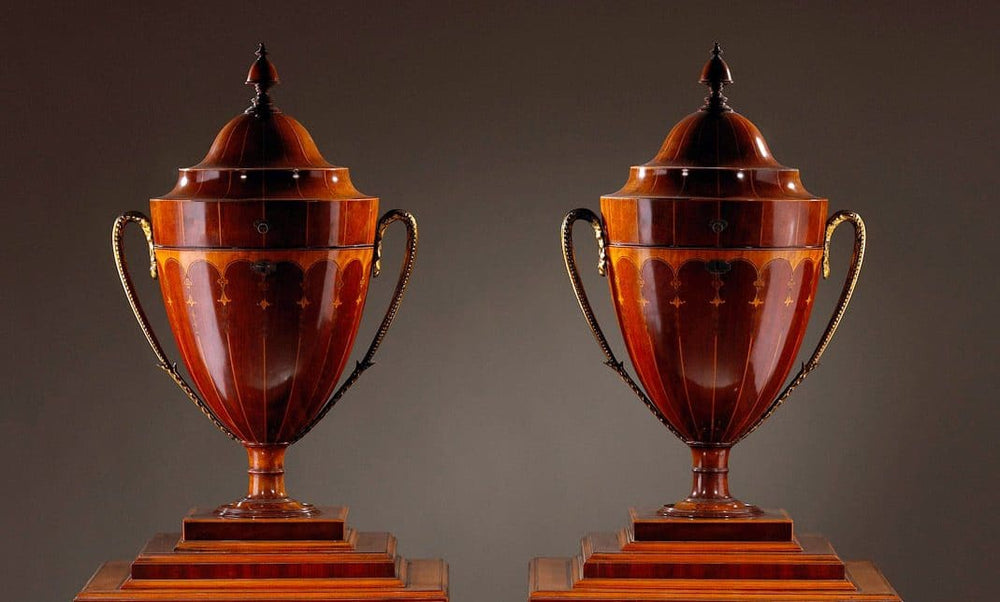 Pair of George III Sheraton Knife Urns on Stands, late 18th century English wooden urns with decorative brass handles.