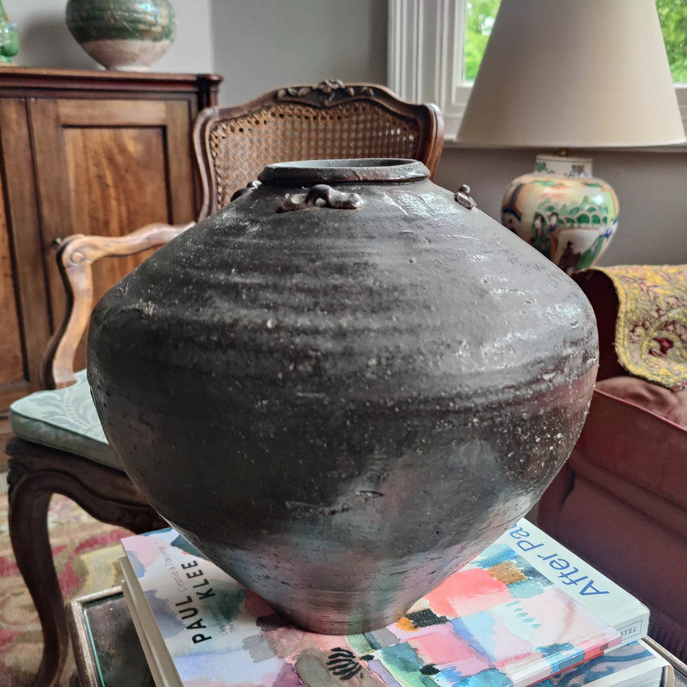 17th century South China Sea dark glazed ceramic storage jar by Nwtiques displayed indoors