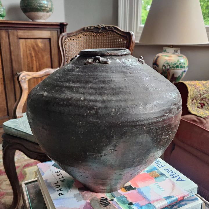 17th century South China Sea dark glazed ceramic storage jar by Nwtiques displayed indoors