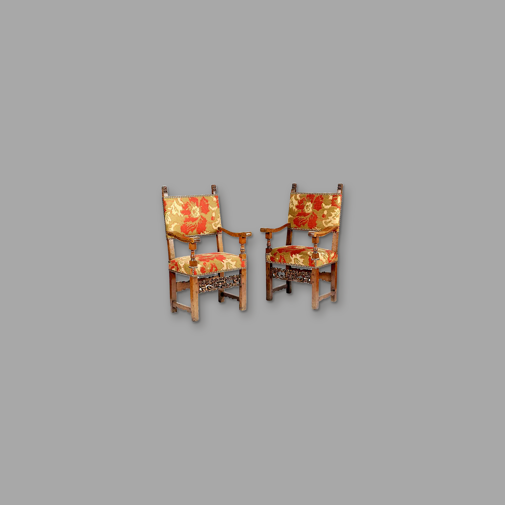 Late Renaissance Italian Walnut Armchairs, on a plain mid-grey background.