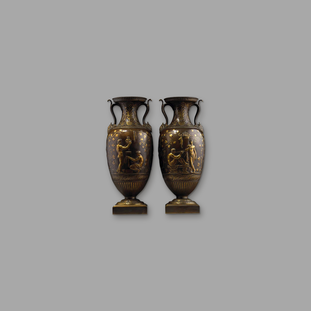 Pair of Bronze and Gilt Classical Vases By Barbedienne, on a plain mid-grey background.