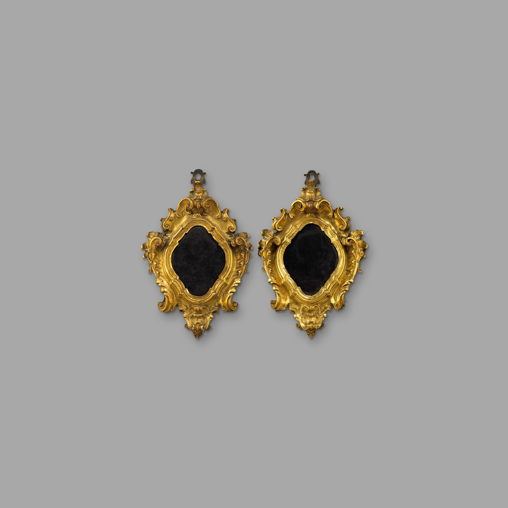 A pair of 17th Century Gilt Bronze picture frames, on a plain mid-grey background.