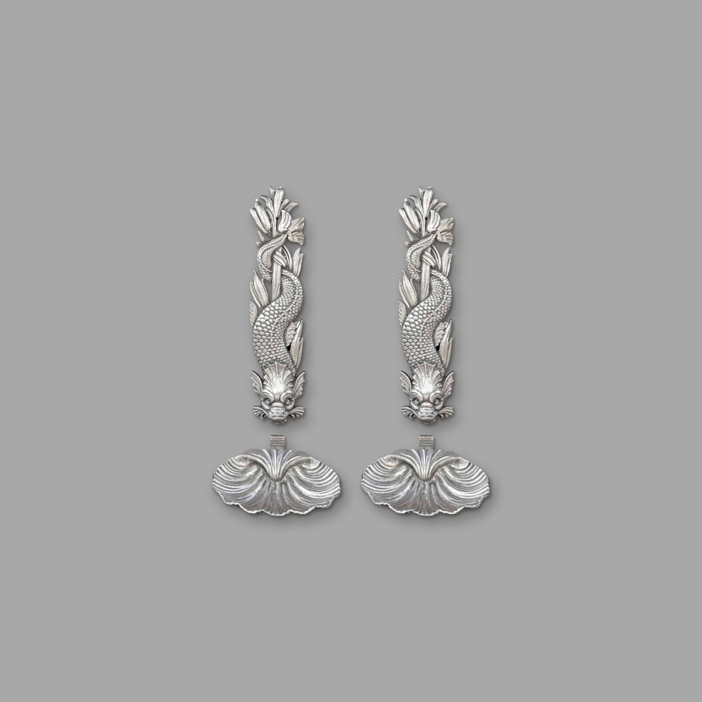 Two Cast Iron classical Dolphin Wall Fountains and shells, on a plain mid-grey background.