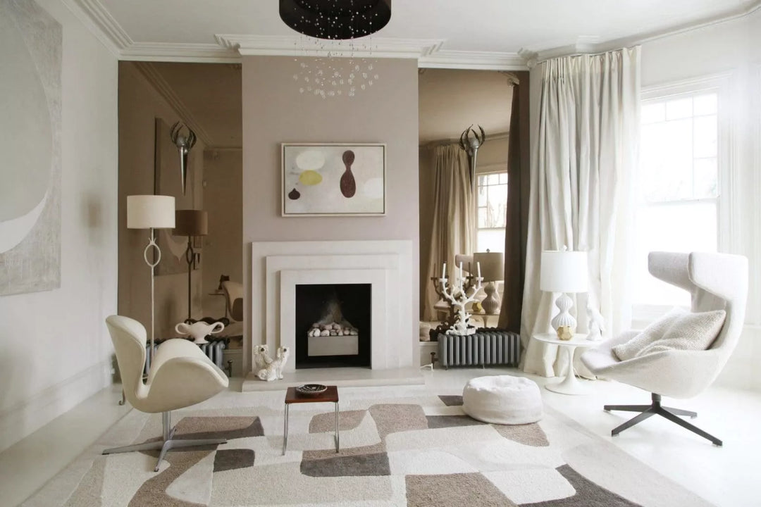Modern living room with neutral tones, fireplace, and stylish seating by Nwtiques