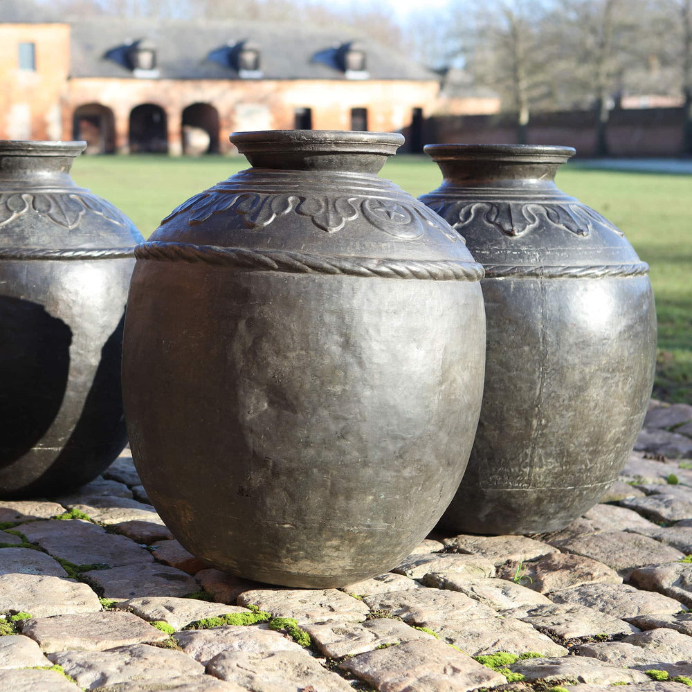 Set of four large antique Sindh bronze pots from Collection EE10, featuring intricate designs and wide openings.