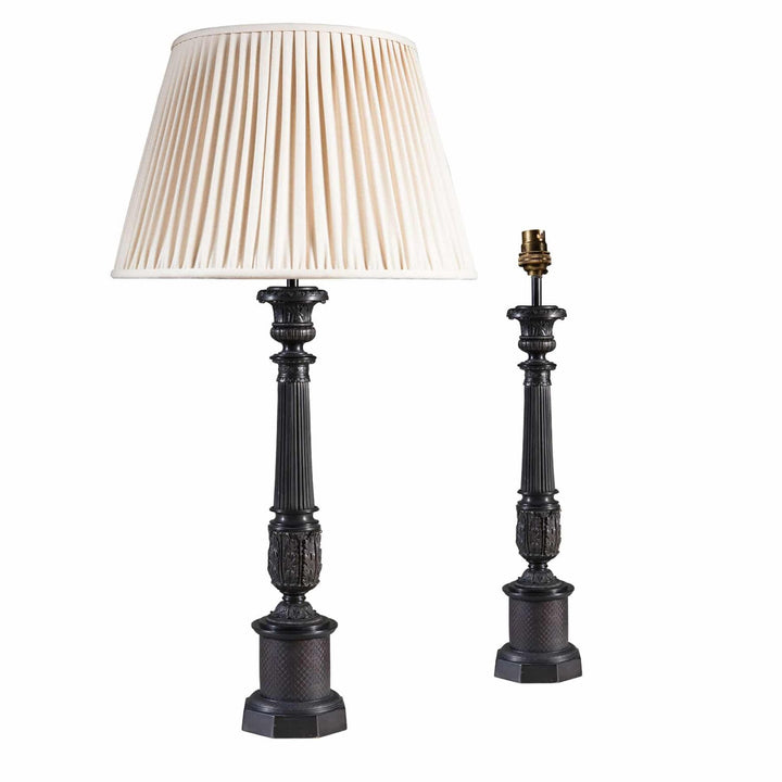 Pair of Dark Bronze Empire Column Lamps After The Antique AJX with one lamp having a cream pleated shade and one without shade