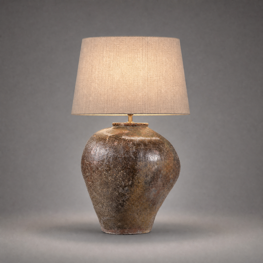 Table lamp with a textured brown base and beige lampshade on a gray background