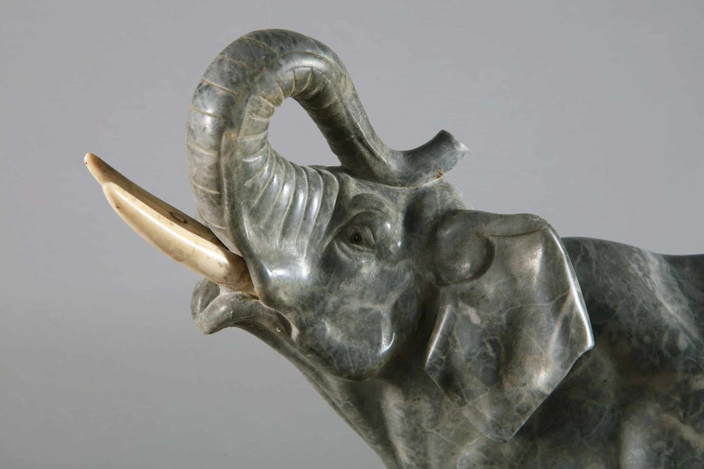 Grey Marble sculpture of an Elephant with raised trunk carved from grey marble on a Portoro marble base circa 1880.