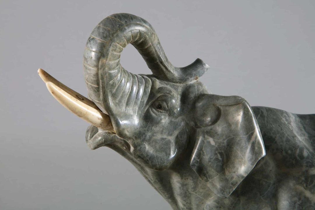 Grey Marble sculpture of an Elephant with raised trunk carved from grey marble on a Portoro marble base circa 1880.