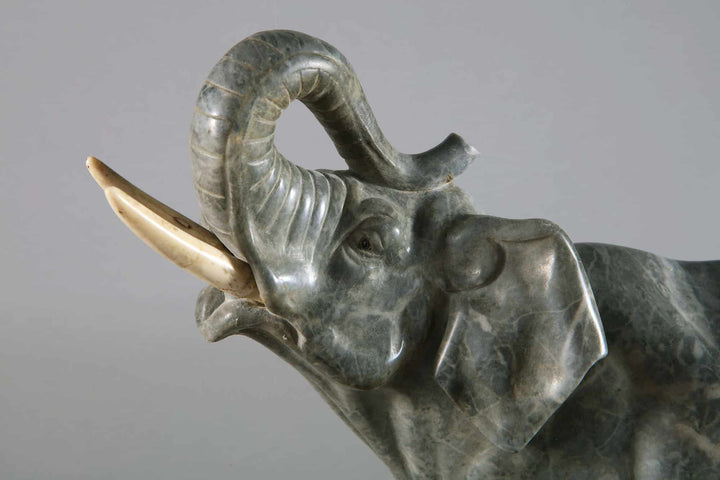 Grey Marble sculpture of an Elephant with raised trunk carved from grey marble on a Portoro marble base circa 1880.