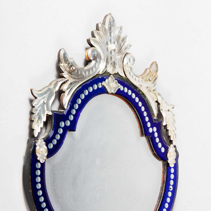 Early 20th Century Venetian blue border glass mirror with shield form, beveled edges, and stylized foliate details