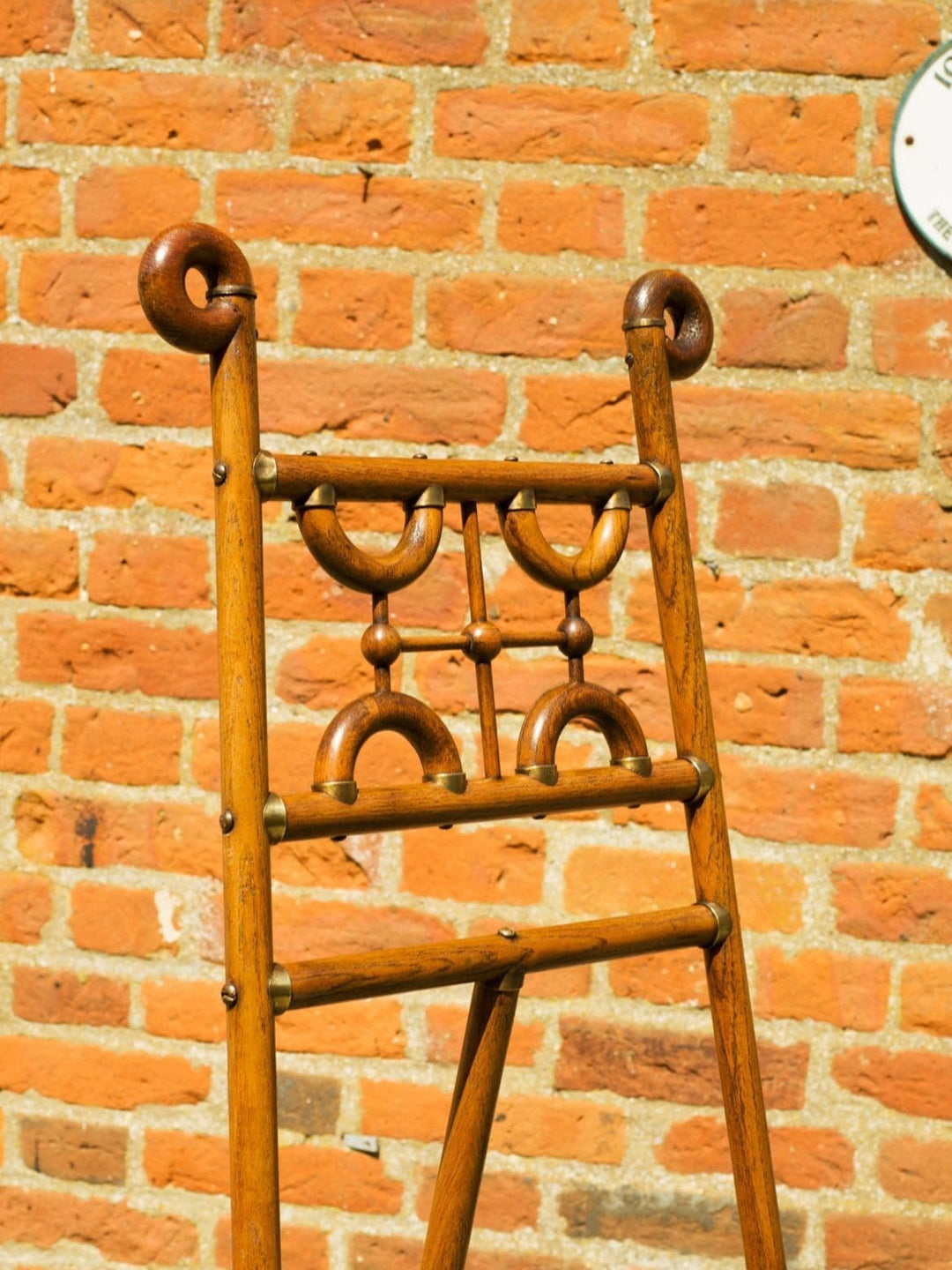 Arts and Crafts oak and brass easel with geometric detailing from Collection CK10 against a brick wall background