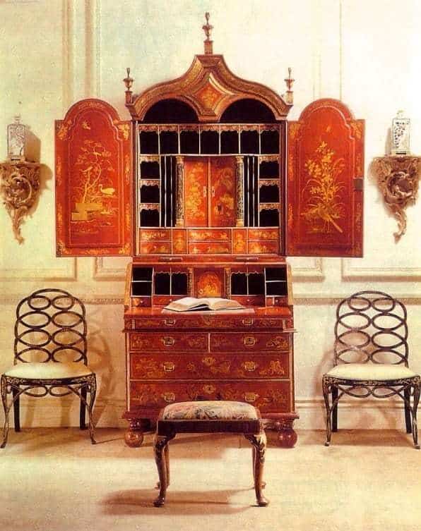 Two matt white Loop Chairs by Collection EE30 with hoop backs beside antique ornate wooden cabinet and stool.