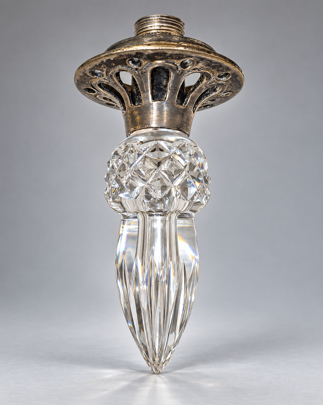 Finial with silver-toned metal mount photographed on a neutral gray background.