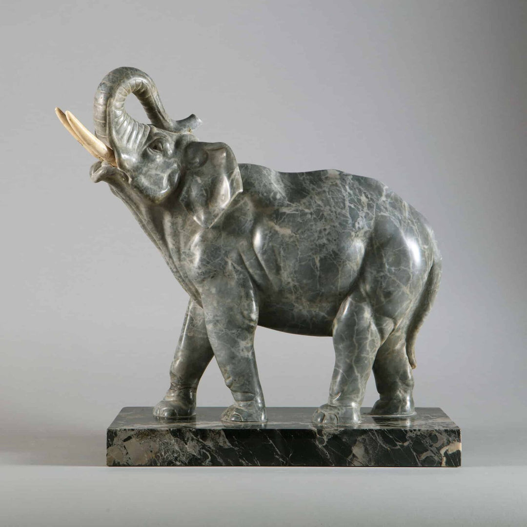 Grey Marble sculpture of an Elephant with raised trunk carved from grey marble, mounted on Portoro marble base, circa 1880.