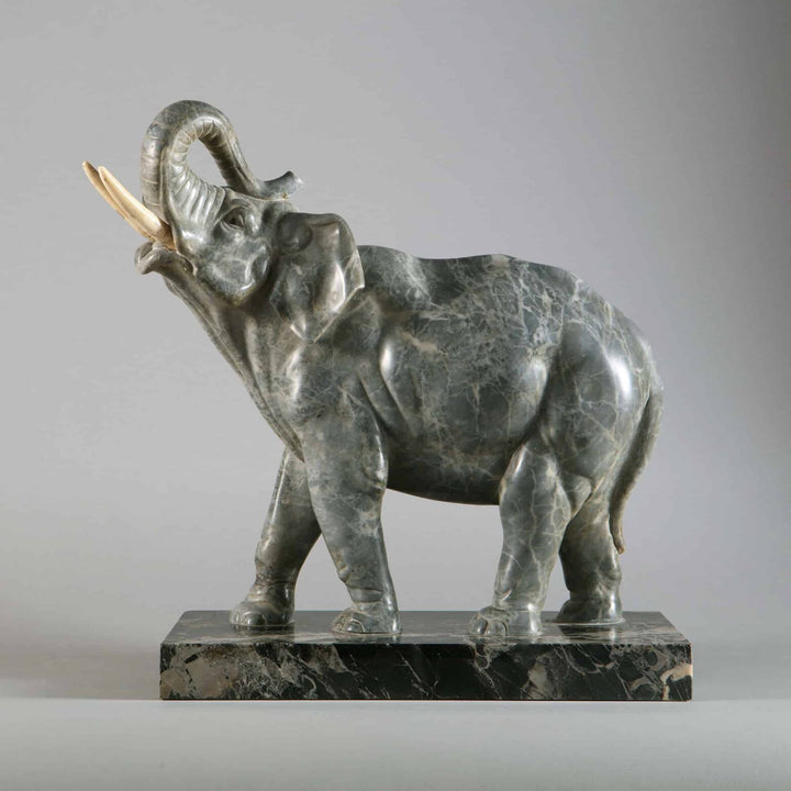 Grey Marble sculpture of an Elephant with raised trunk carved from grey marble, mounted on Portoro marble base, circa 1880.