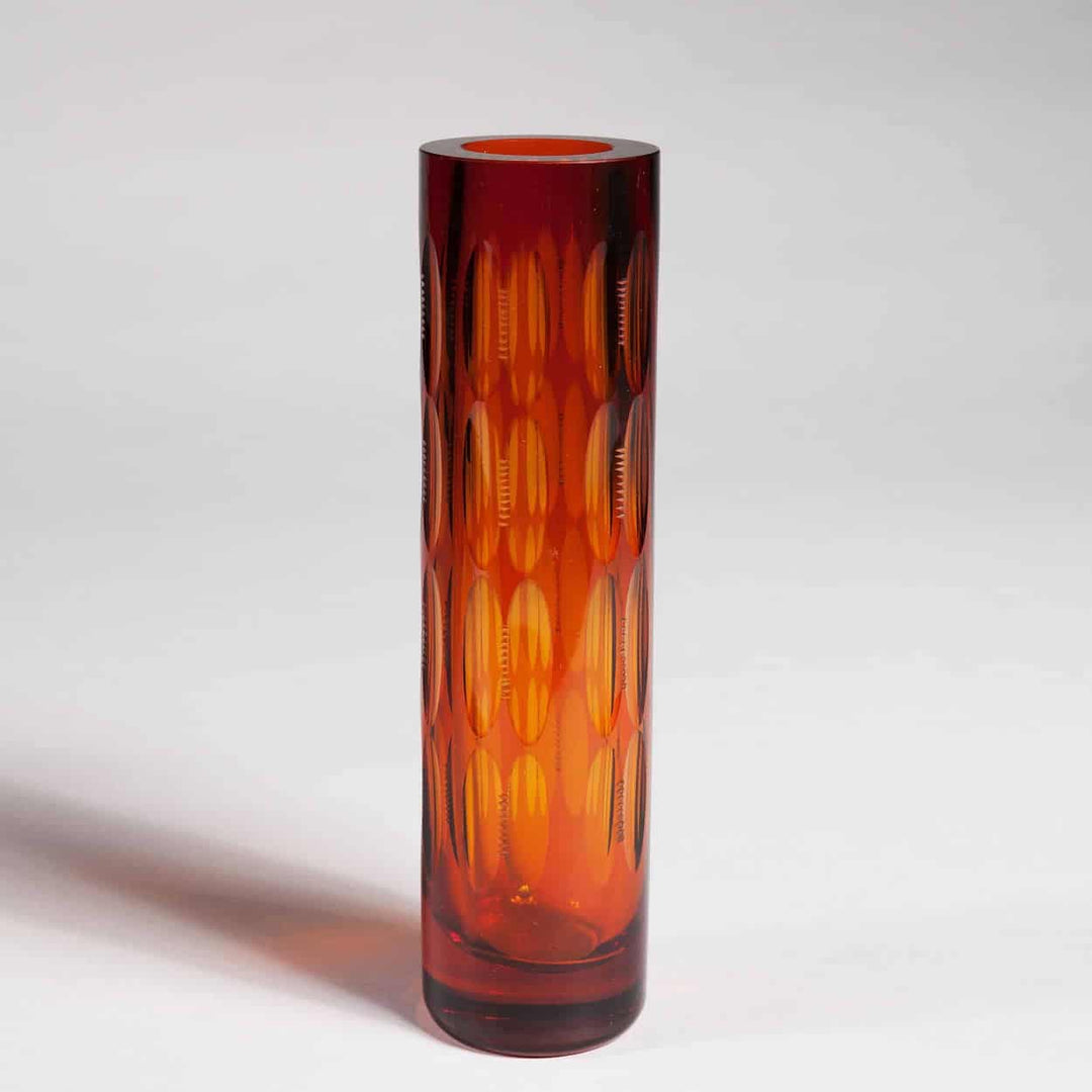 Tall cylindrical mid century Bohemian orange glass vase with cut patterns by Collection TH20 on white background