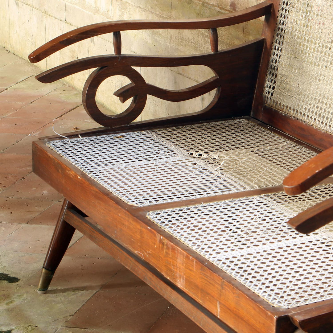 Early 20th century Bombay Art Deco settee with caned panels and Q motif arms from Collection EE20, needing cane repair