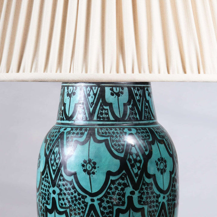 North African Turquoise Vase as a Table lamp showing turquoise and black patterned vase with cream pleated lampshade