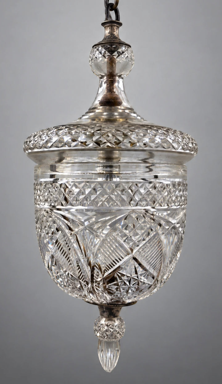 A vintage cut glass pendant light fixture with a silver-toned metal top and chain, set against a neutral gray background. By Osler