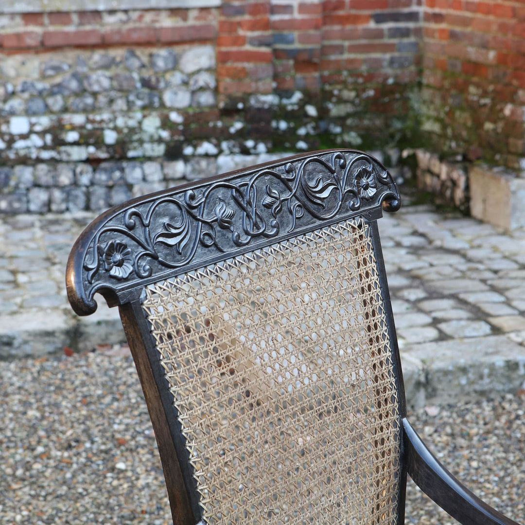 Close-up of carved ebony top rail and cane back of 19th century Anglo Indian armchair by ANTIQUES