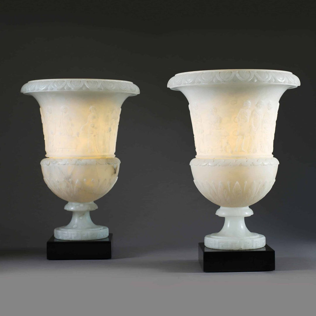 Pair of classical carved alabaster vase lamps with relief figures and black bases by The Sold Archive