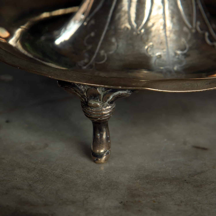 Close-up of scroll foot on a European silver candlestick from Collection EE10 with detailed foliate design
