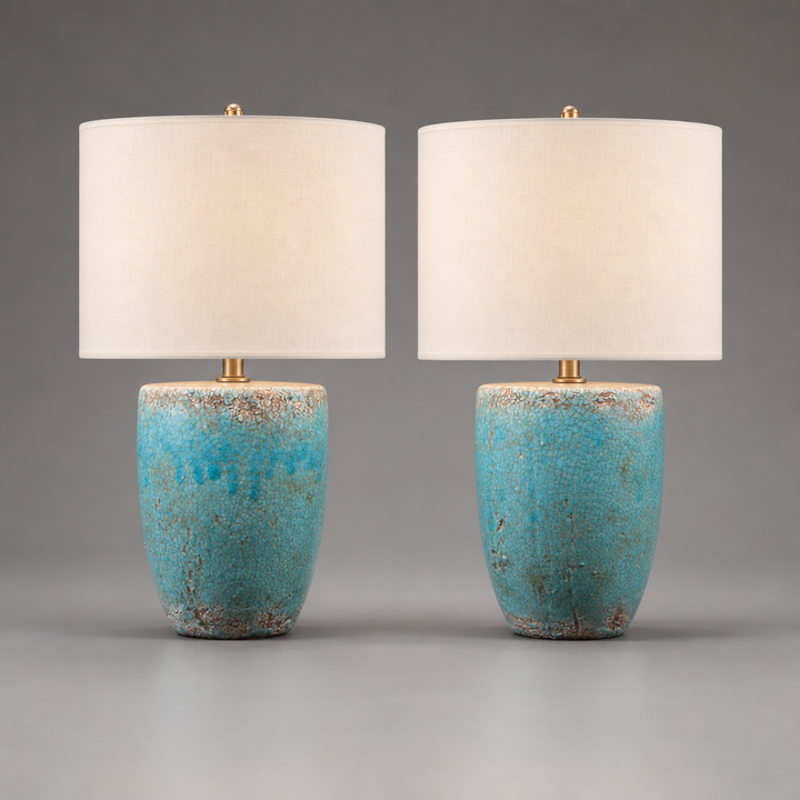 Two table lamps with turquoise bases and white shades on a gray background