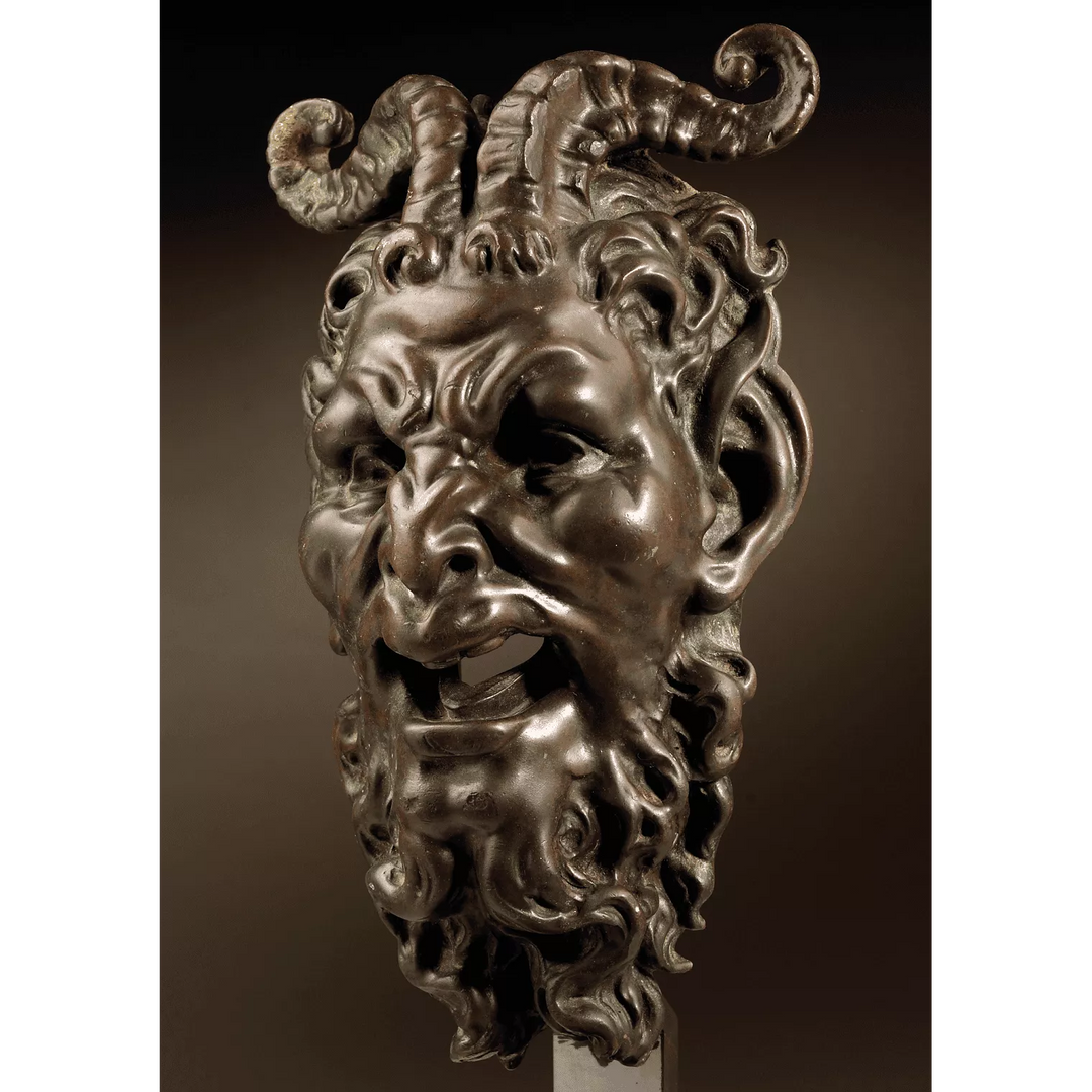 Bronze mask of a Satyr Fountain Head with curled horns and detailed beard, patinated bronze, mounted on a stand.
