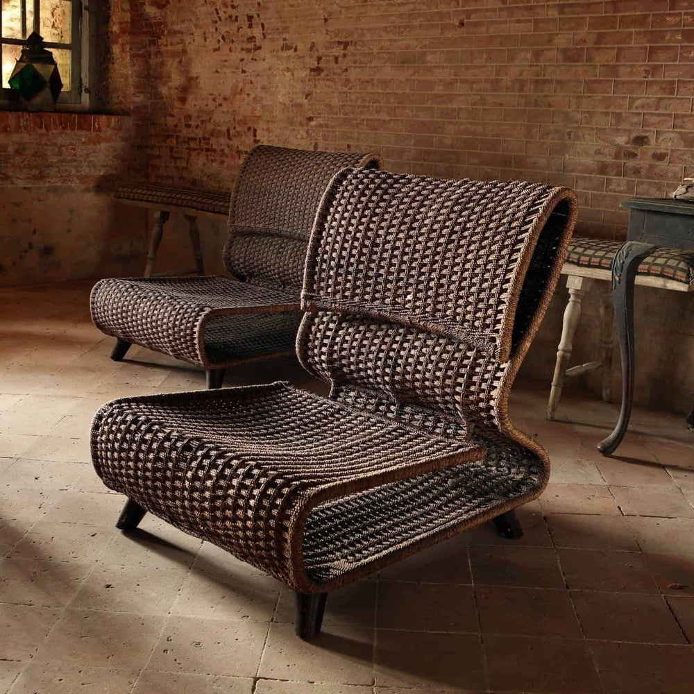 Pair of modernist easy chairs with woven seats and metal frames by Collection EE30 in rustic interior setting