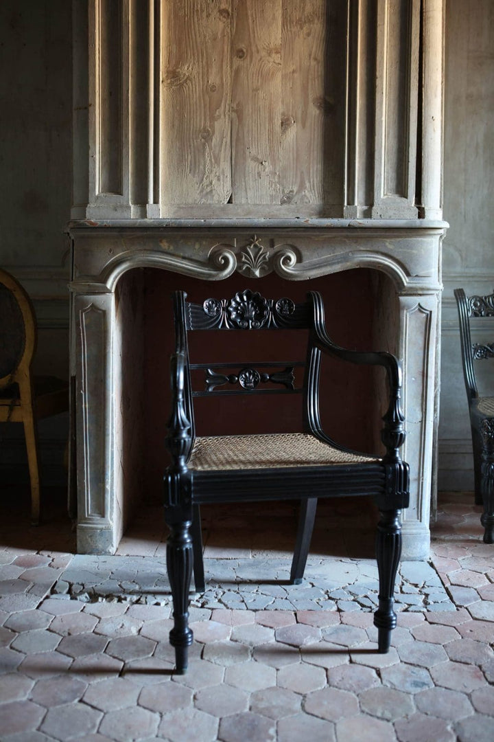 Anglo-Indian ebony armchair with cane seat and intricate carvings from Collection EE30, mid-19th century Ceylon design.