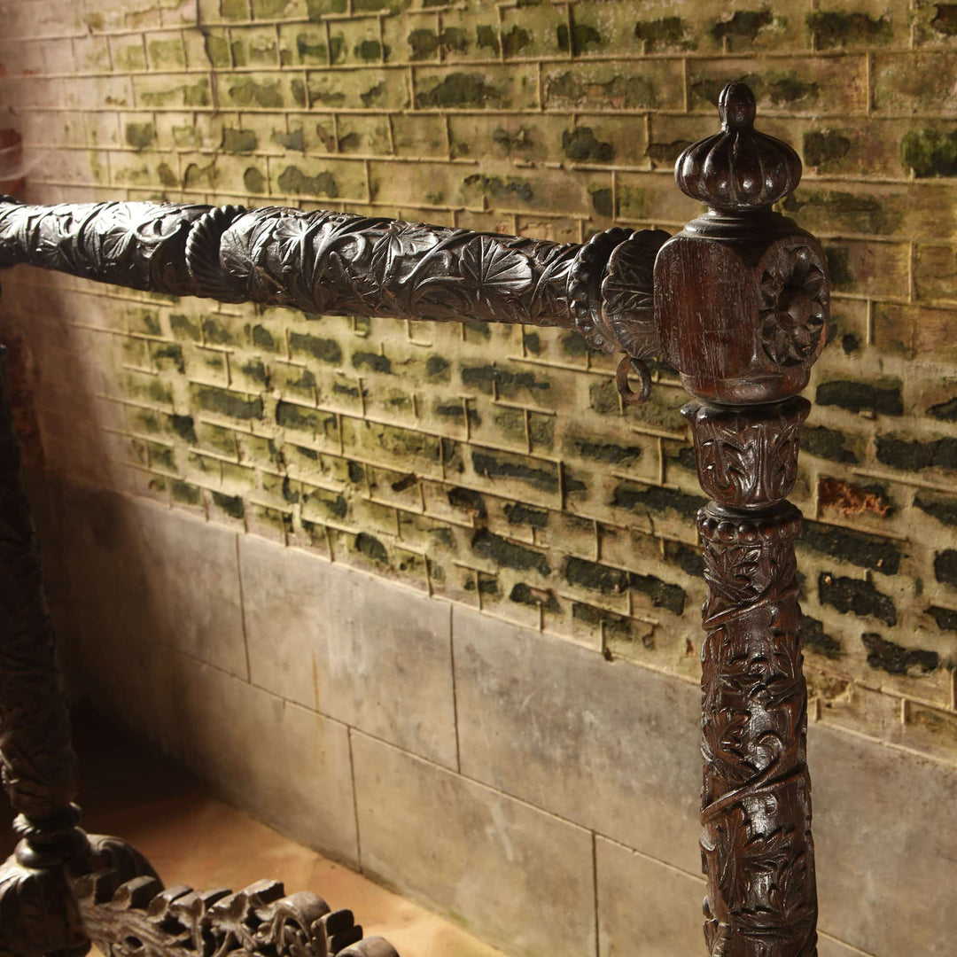 Detailed carved teak column of 19th century antique Indian gong stand from Collection EE20 against rustic brick wall