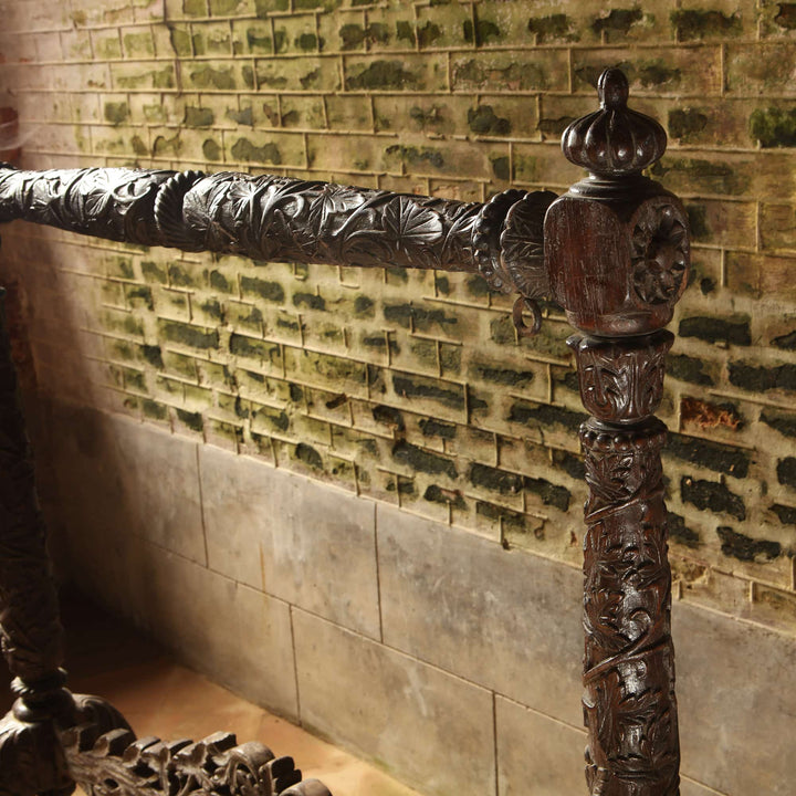 Detailed carved teak column of 19th century antique Indian gong stand from Collection EE20 against rustic brick wall