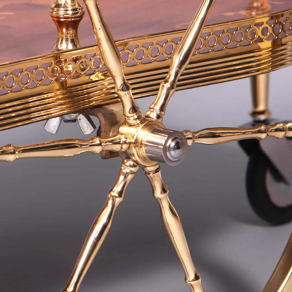 Close-up of polished brass detailing and wheel mechanism on Nicholas Wells Antiques mid century Italian marquetry drinks trolley