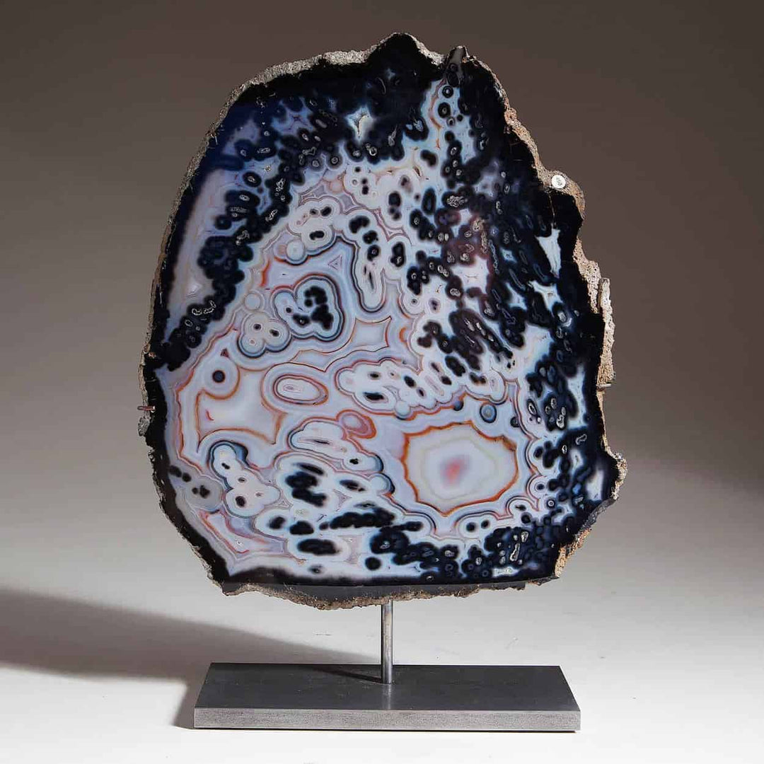 Polished agate on stand with intricate black and white patterns from Collection CK10 displayed on gray background