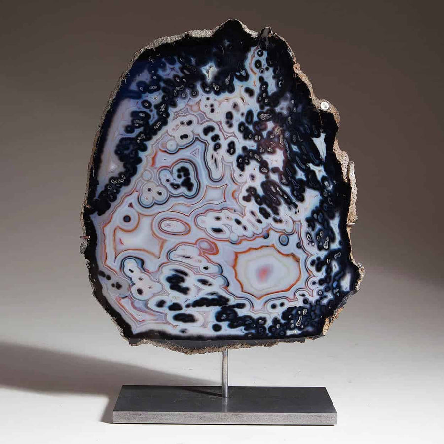 Polished agate on stand with intricate black and white patterns from Collection CK10 displayed on gray background