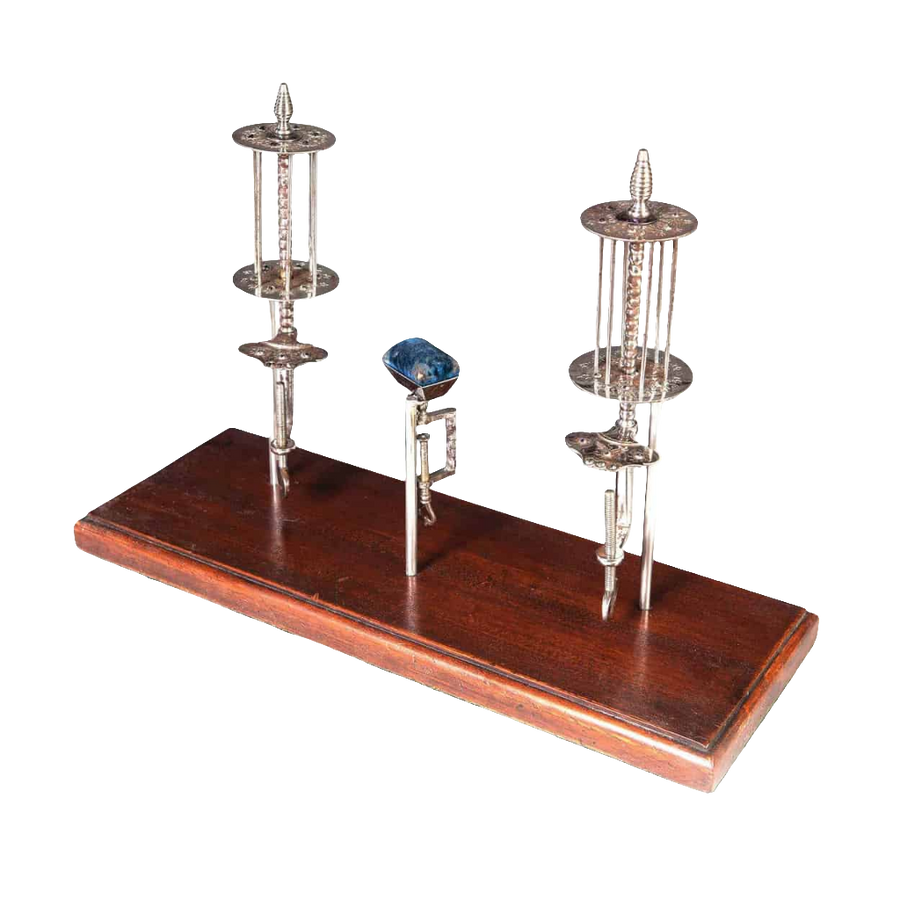 A Group Of Cut Steel Plombieres needlework accessories from Collection TH20 on a wooden display stand.