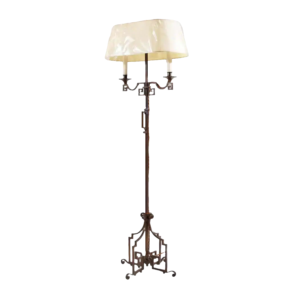 A patinated Steel floor standing bouillotte lamp with key scroll base and adjustable two-branch shaded light, circa 1920.