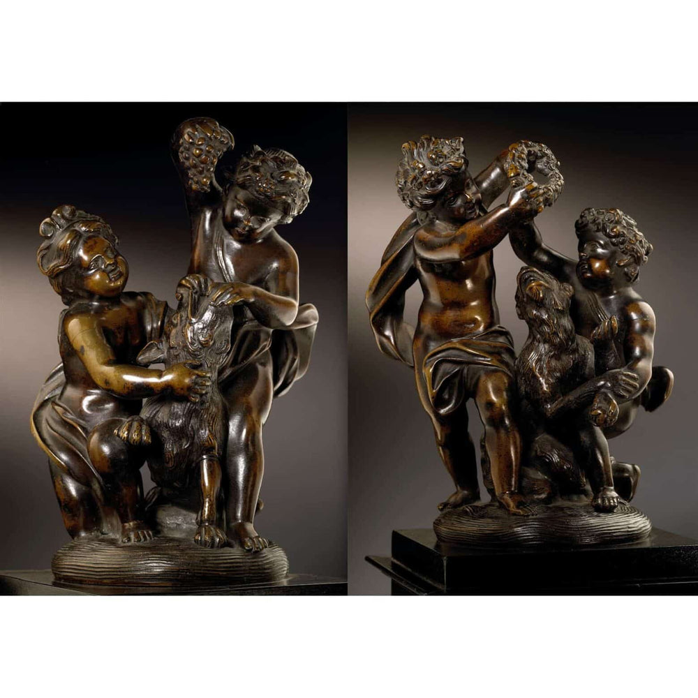 Pair of bronze cherub groups depicting cherubs playing with a dog and monkey, holding garlands and grapes.