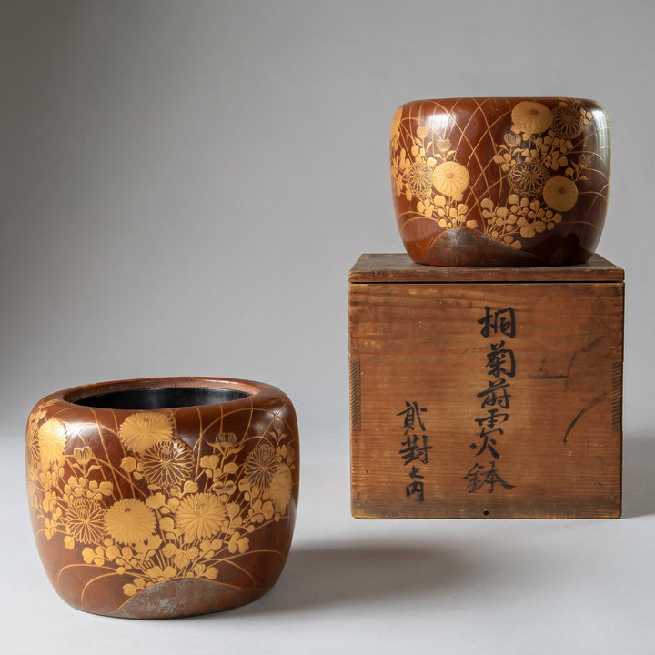 Two wooden containers with floral patterns and a wooden box with Japanese text on a gray background