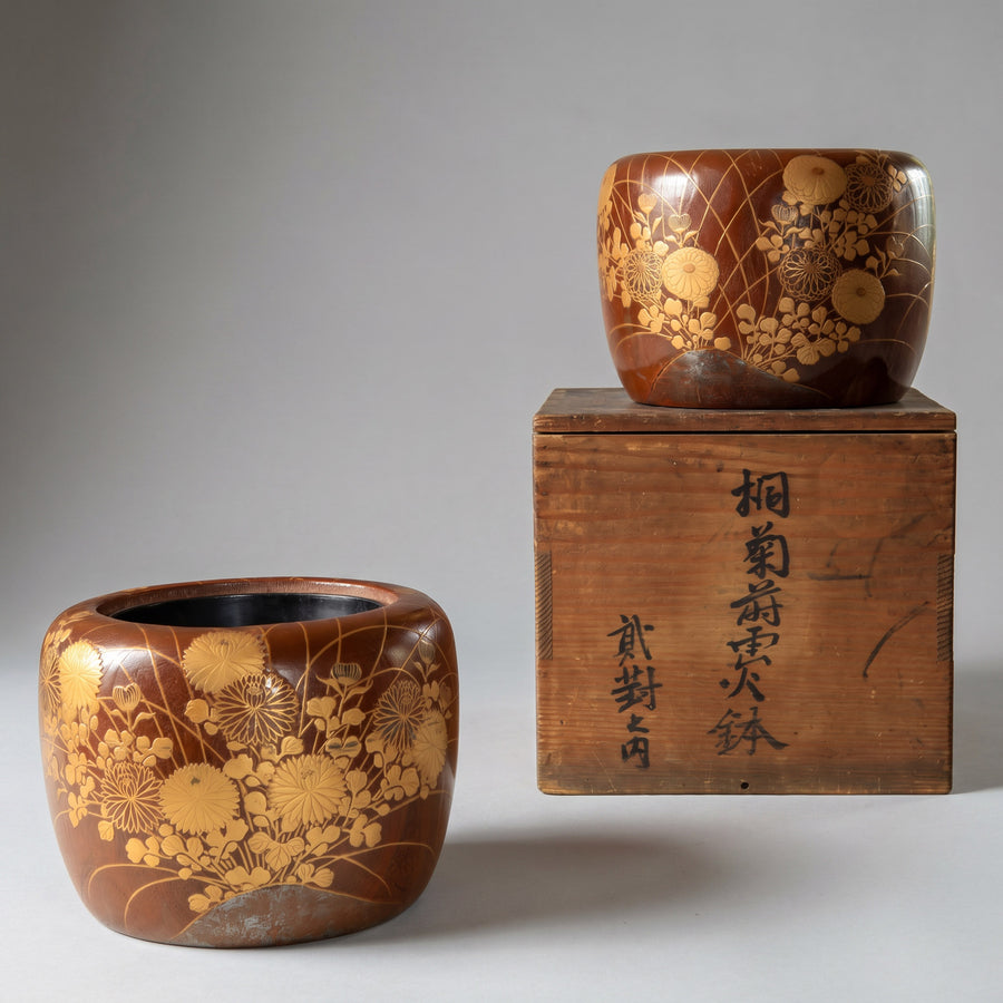 Two wooden containers with floral patterns and a wooden box with Japanese text on a gray background