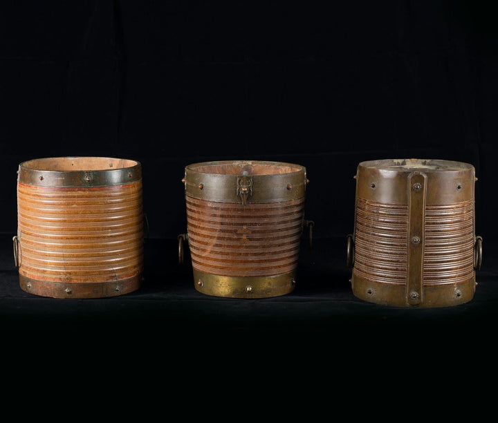 Three brass bound turned teak rice measures from Collection EE20 with ribbed bodies and brass mounts