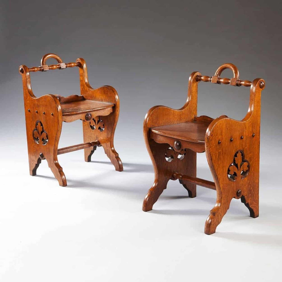 A pair of oak arts and crafts stools with trefoil pierced sides and carrying handles by The Sold Archive