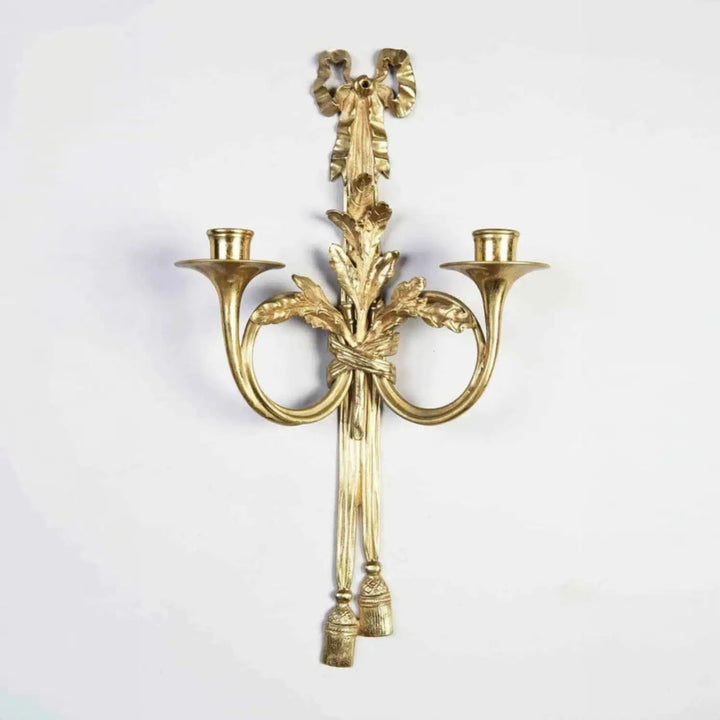 Pair of Louis XVI style gilt-bronze wall lights with two arms shaped as French horns and oak leaf decor.
